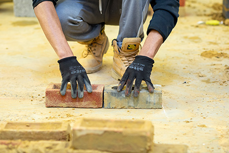 Student learning how to lay bricks 